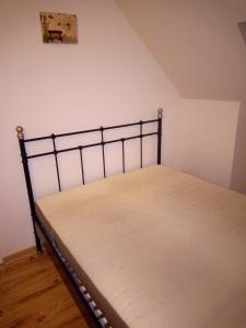 uma cama com uma armação de metal num quarto em Plusieurs chambres à 20 km au sud de Paris em Ballainvilliers