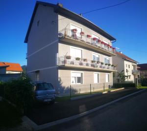 a building with a blue van parked in front of it at Apartment Tina Gračac in Gračac