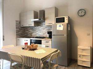 a kitchen with a table and a refrigerator at White Sand Alghero in Alghero