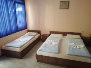 two beds sitting in a room with a window at Ваканционно селище СБХ in Shkorpilovtsi