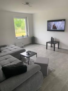 a living room with a couch and a flat screen tv at Apartamenty "Marynarska " Rusinowo in Rusinowo