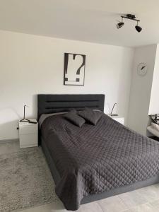 a bedroom with a bed with a black comforter at Apartamenty "Marynarska " Rusinowo in Rusinowo