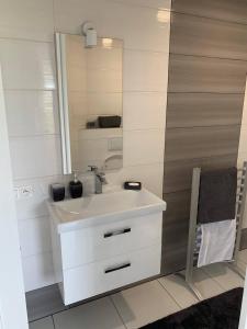 a bathroom with a white sink and a mirror at Apartamenty "Marynarska " Rusinowo in Rusinowo