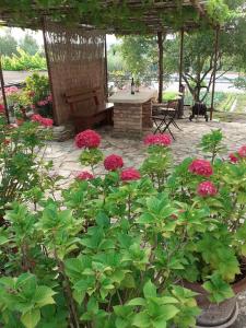 un jardín con flores rosas y un banco de madera en Apartma Fiorina, en Sečovlje