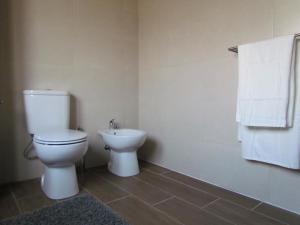 ein Bad mit einem WC und einem Waschbecken in der Unterkunft Casa das Nações in Donas