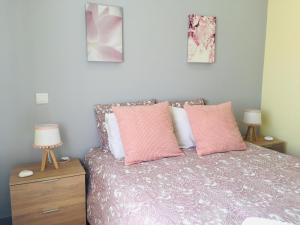 ein Schlafzimmer mit einem Bett mit rosa und weißen Kissen in der Unterkunft Quinta dos Netos in Tavira + 34 Fotos