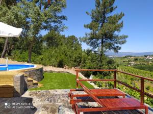 a deck with a bench next to a swimming pool at Casa das Vinhas Velhas by Casa do Poço in Peso da Régua