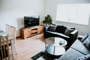 a living room with a couch and a tv at Flats near football clubs in Liverpool
