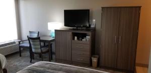 a hotel room with a television on a dresser with a desk at Best Western Intracoastal Inn in Jupiter