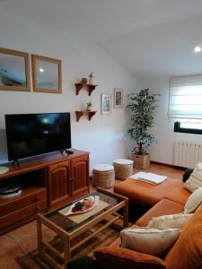 sala de estar con sofá y TV de pantalla plana en Apartamentos Marsó, en Poio