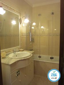 W łazience znajduje się umywalka i prysznic. w obiekcie Cezimbra Guest House w mieście Sesimbra