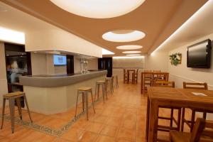 un restaurante con bar y mesas y sillas de madera en Hotel Valentin, en Aguilar de Campóo
