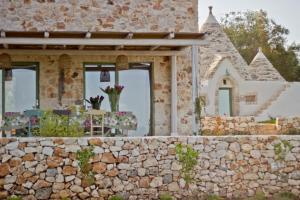 una pared de piedra frente a una casa con ventanas en Trullo il Gatto Nero, en Ostuni