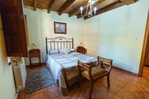 a bedroom with a bed and a chair at Casa Rural La Galana in Sames