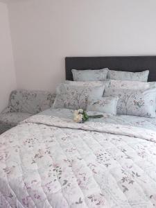 uma cama com uma flor em cima em Flat 1 - Entire Modern Studio with en-suite and free Parking close to QMC, City centre & Notts Uni em Nottingham