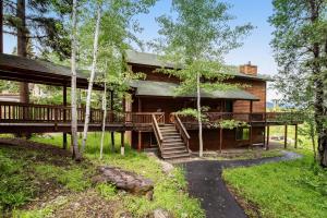 Una casa de troncos con terraza y escalera. en Cedar Lane Getaway, en McCall