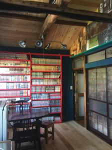 een kamer met een tafel en een bos boeken bij 一棟貸し宿bochi-bochi in Komagane