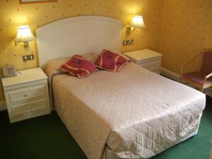 a bedroom with a bed, a lamp, and a dresser at Elstead Hotel in Bournemouth