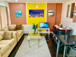 uma sala de estar com um sofá e uma mesa em London Luxury 2Bedrooms, Reception, Garden, Apartment em Ilford