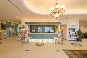 een lobby met een balie en tafels en stoelen bij Izumo Royal Hotel in Izumo