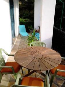 stół i krzesła z parasolem na patio w obiekcie Appartement de 2 chambres avec jardin clos et wifi a Bocognano w mieście Bocognano