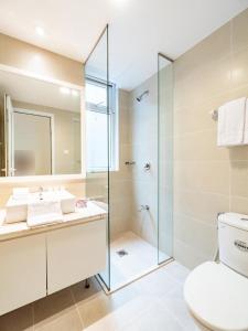 a bathroom with a shower and a toilet and a sink at Glenwood Residences in Ho Chi Minh City