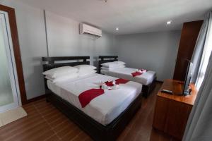 a bedroom with two beds with red bows on them at One Averee Bay Hotel in Coron