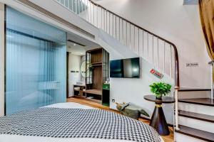 a bedroom with a bed and a staircase at Happy Dragon City Culture Hotel-Tianjin Draum Tower & Dayuecheng shopping mall in Tianjin