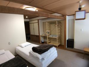 a room with two beds and a tv in it at Villa Alpen in Yamanouchi