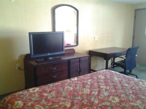 1 dormitorio con 1 cama, TV y escritorio en Xenia Country Inn, en Xenia