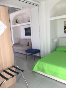 a bedroom with a green bed and a couch at Gresy Appartamento Suite in Positano