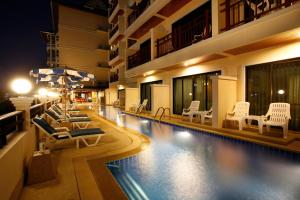 a hotel swimming pool with lounge chairs and umbrellas at Jiraporn Hill Resort in Patong Beach