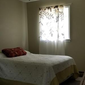 a bedroom with a bed and a window with a curtain at Amazing Views! Hunter Mt 5 Bedroom Home! Best location surrounded by beautiful Mt views! Enjoy Lakes, Ski Slopes & Firepit under Stars! in Hunter +11 photos