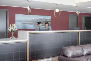 two women sitting at a reception counter in a hotel room at Peppers Bluewater Resort in Lake Tekapo