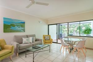 een woonkamer met een bank, stoelen en een tafel bij Regal Port Douglas in Port Douglas