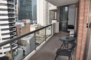a balcony with a table and chairs on a building at Accommodation Sydney City Centre - 2 Bedroom Apartment with Balcony on Top Floor in Sydney