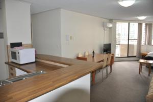 a living room with a table and a microwave at Accommodation Sydney - Kent Street Sydney CBD Top floor 2 bedroom apartment with balcony in Sydney