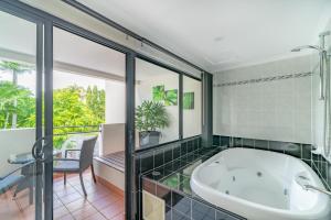 a bath tub in a bathroom with a window at Regal Port Douglas in Port Douglas