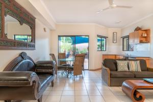a living room with a couch and a table at Regal Port Douglas in Port Douglas