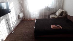 ニジネヴァルトフスクにあるApartment on Mira 15のベッドルーム(ベッド1台、椅子、テレビ付)