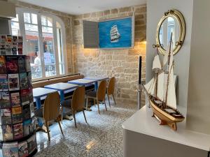 a dining room with a table and a boat on the wall at Hôtel L'Amiral in Paris