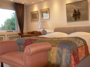 a bedroom with a bed and a chair and a window at Die Villa Mettmann in Mettmann