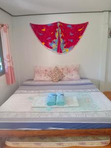 a bed with a pair of blue shoes on it at Lung Teeb Paradise Chao Lao Resort in Chao Lao Beach