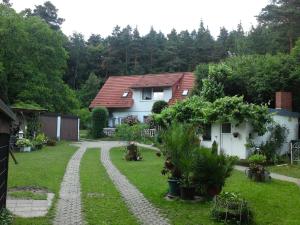 a house with a gravel path in the yard at Ferienwohnungen Behling am Schufutsberg in Liepe