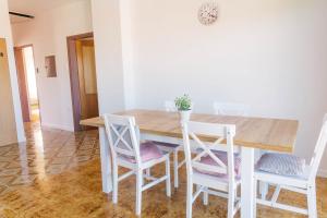 a dining room with a wooden table and chairs at Sobe Kaki in kivi in Izola