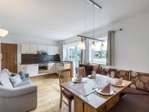 a kitchen and living room with a table and a couch at Apartment Gossner in Westendorf