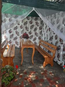 a tent with a bench and a table with flowers at Mini Hotel Уютный дворик in Odesa