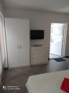 a bedroom with a tv and a dresser with a bed at Tomić in Novi Vinodolski