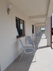 een rij stoelen en tafels in een gebouw bij Casa ERICKA in Vama Veche
