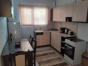 uma pequena cozinha com uma mesa e um frigorífico em Къща за гости Калинови em Sandanski